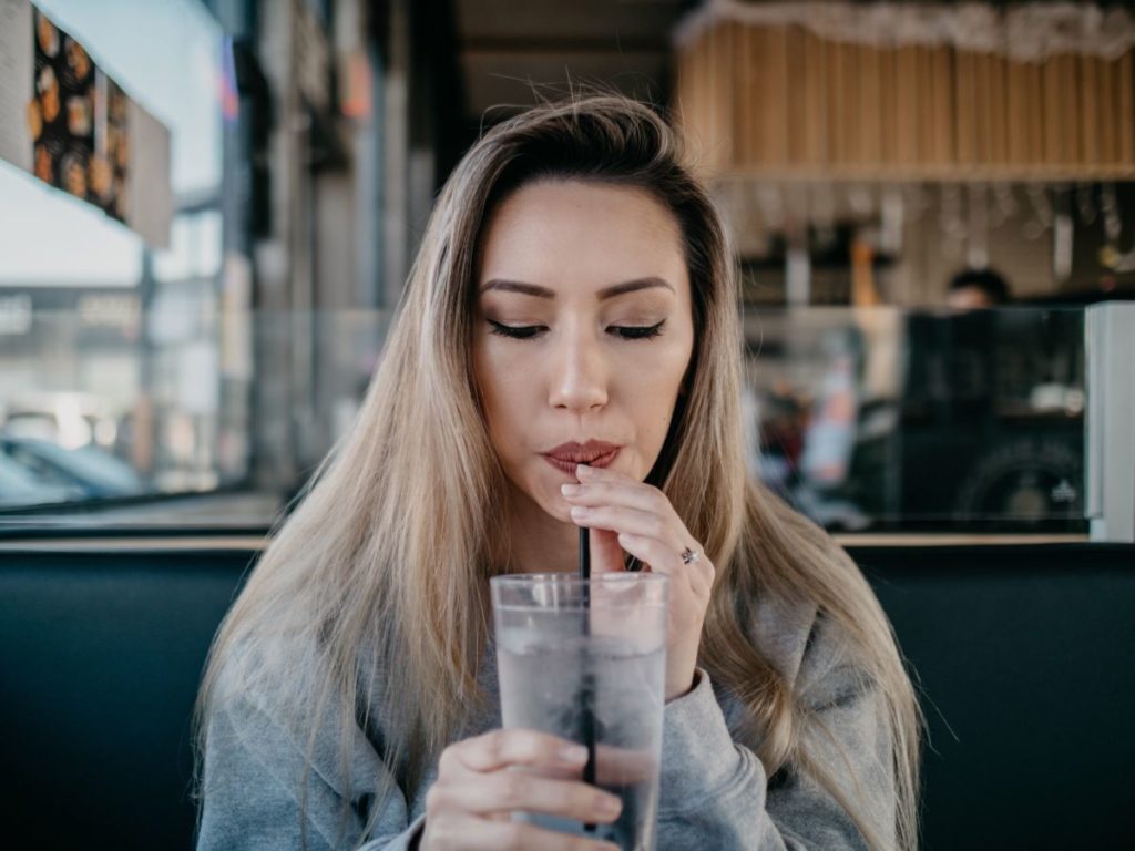 pretty woman drinking milkshake practising how to flirt with a guy